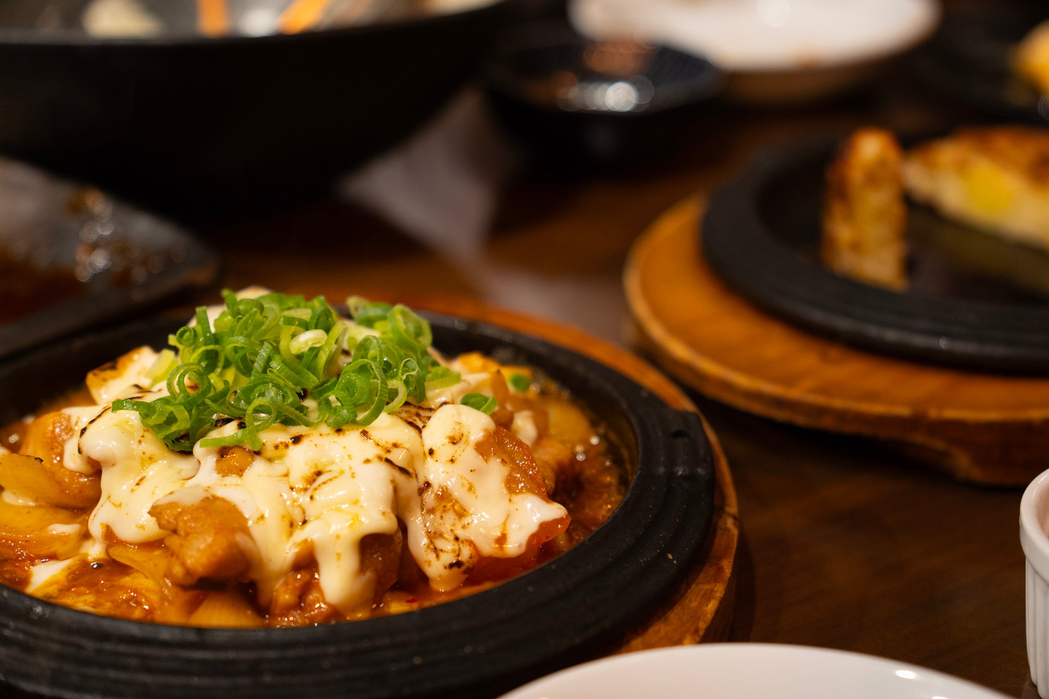 Cheese dakgalbi topped with melted cheese and green onion at Chijimi in Noda