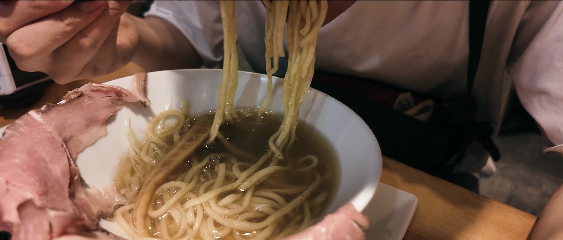 Noodles lifted from a bowl of ramen at the end of the evening