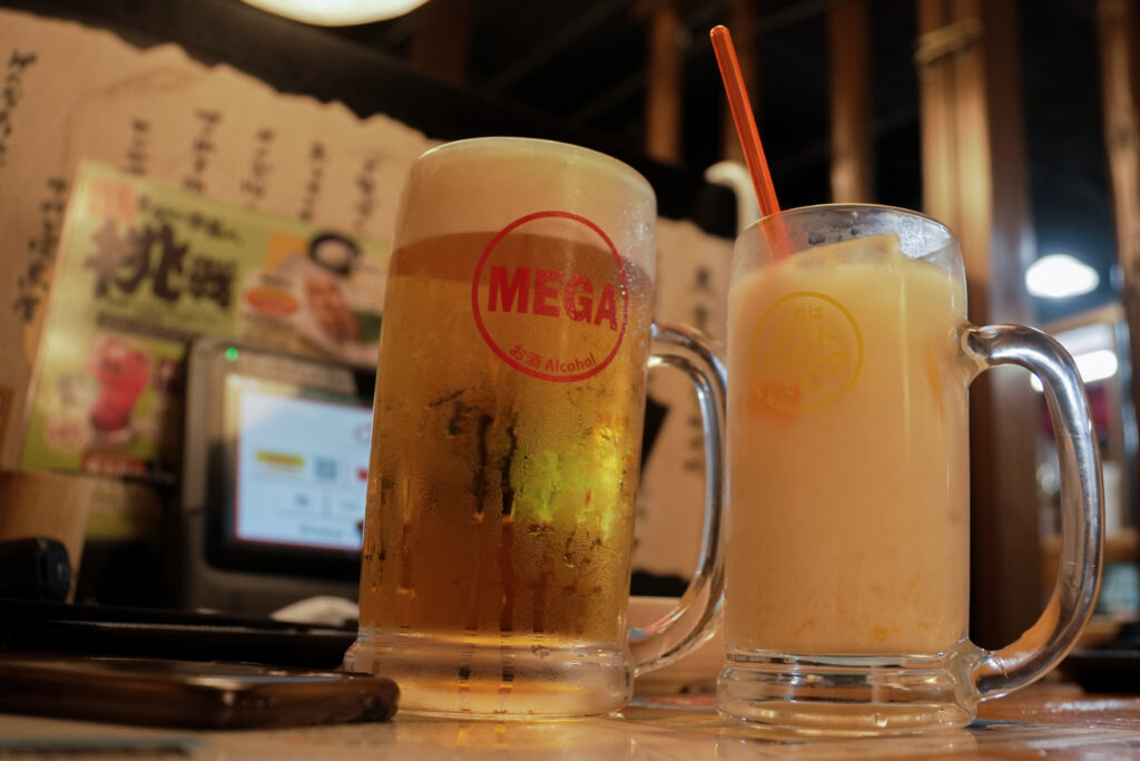 A large Mega Kinmugi mug on the left, beside another drink at Torikizoku