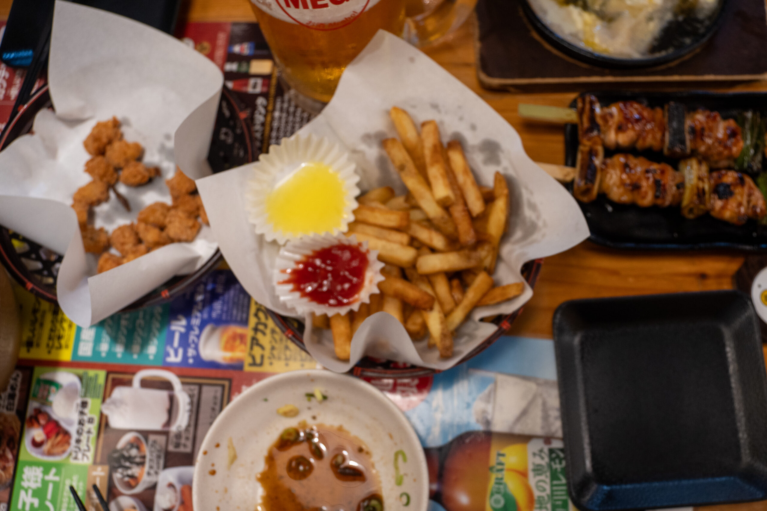 Fried chicken cartilage on the left, fries in the center, and large Kizokuyaki chicken skewers on the right